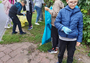 Uczniowie klasy 3. biorą udział w sprzątaniu terenu w okolicach Bajkolandii