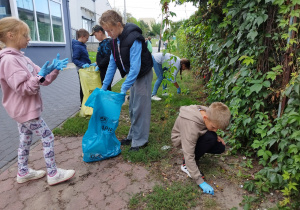 Uczniowie klasy 3. biorą udział w sprzątaniu terenu w okolicach Bajkolandii