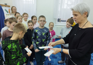 Pani rozdaje pamiątkowe zakładki