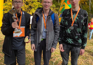 Trzech chłopców trzymający puchar