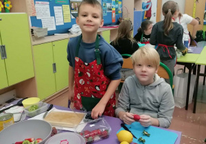 Uczniowie wykonują sałatkę owocową