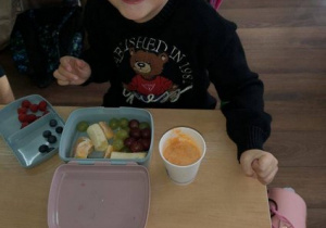 Uśmiechnięta dziewczynka ze swoją owocową śniadaniówką