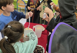 Dzieci wyławiają karteczki z marzeniami.