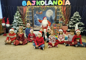 Uczniowie klasy pierwszej pozują do zdjęcia z Mikołajem.