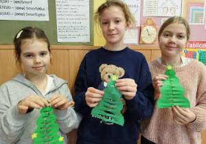 Dziewczynki pokazują swoje choinki z papieru