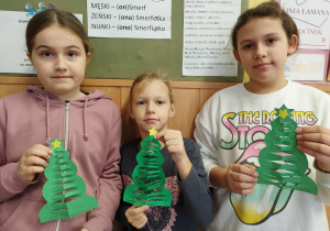 Dziewczynki pokazują swoje choinki z papieru