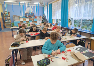 Uczniowie klasy 3b odrysowują, wycinają i ozdabiają pierniki z tekturki