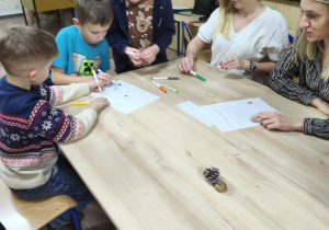 Dzieci wykonują świąteczny rysunek według instrukcji.