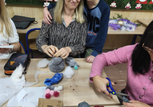 Rodzice wspólnie z dziećmi wykonują świąteczne upominki.