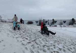 Uczniowie klasy 3 B zjeżdżają na sankach z górki