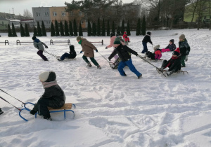 Zabawy na śniegu z sankami