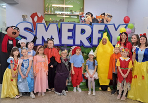 Bajkowe postacie na tle smerfnej dekoracji