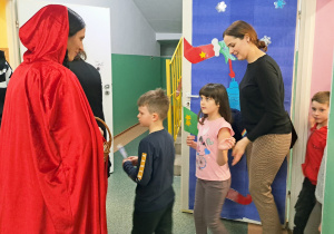 Pani przebrana za Czerwonego Kapturka wita gości