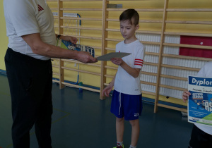 Uczeń odbiera dyplom