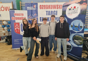 Uczniowie na tle baneru podczas Targów Edukacyjnych