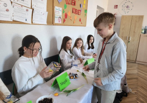 Kolega z klasy wręczający upominek koleżankom z okazji Dnia Kobiet