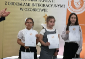 Karina prezentuje dyplom za wyróżnienie