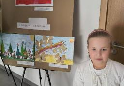 Dziewczynka prezentuje dyplom za zajęcie drugiego miejsca.jpg