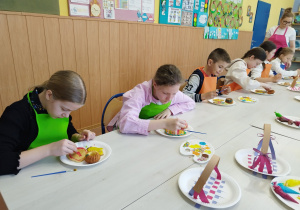 Dzieci ozdabiają ciasteczka.