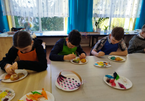 Dzieci ozdabiają ciasteczka.