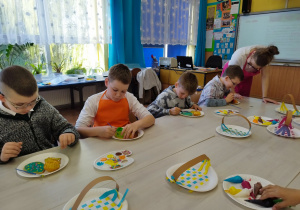 Dzieci ozdabiają ciasteczka.