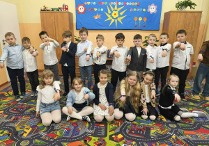 Uczniowie klasy 1 prezentują niebieską wstążkę zawiązaną na nadgarstkach.