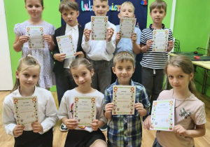 Uczniowie klas pierwszych trzymają dyplomy za udział w konkursie recytatorskim