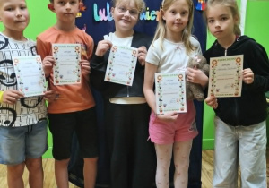 Uczniowie klas drugich trzymają dyplomy za udział w konkursie recytatorskim