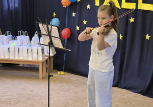 Dziewczynka prezentująca talent muzyczny.