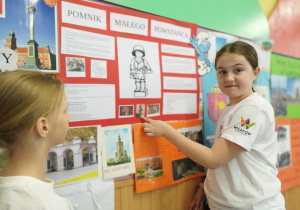 Dziewczynki przedstawiają informacje o Pomniku Małego Powstańca