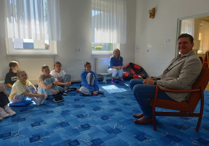 Pan prezentuje czytaną książkę.