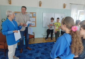 Pani bibliotekarka wręcza certyfikaty uczestnictwa w akcji.