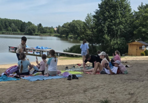 Dzieci siedzą na kocach.