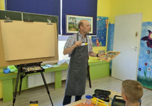 Malarz pokazuje narzędzia.