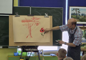 Gość rysuje elementy pejzażu.