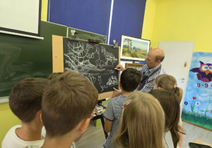 Gość rysuje elementy pejzażu.