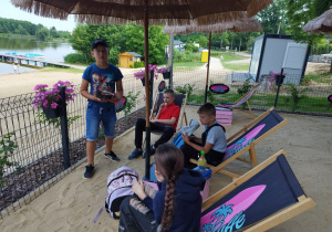 Dzieci siedzą w SurfCafe nad Zalewem Miejskim i jedzą lody
