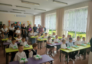 Uczniowie klasy 1 siedzą w ławkach