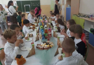 Rodzice zapraszają dzieci na poczęstunek.