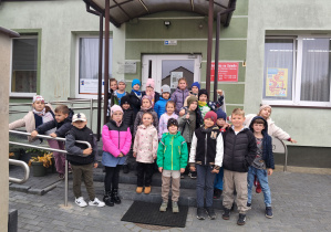Uczniowie klasy 1a stoją przed biblioteką
