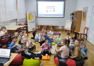 Uczniowie klasy 1a siedzą przed ekranem