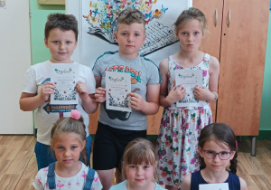 Sześcioro dzieci z klas pierwszych trzyma dyplomy uczestnictwa w konkursie.