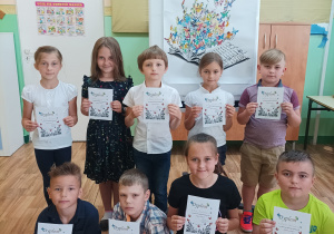 Dziewięcioro dzieci z klas drugich trzyma dyplomy uczestnictwa w konkursie.
