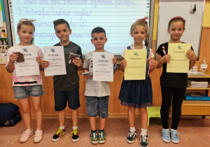 5 dzieci trzyma dyplomy i nagrody za szkolny konkurs "Netykieta"