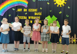 Siedmioro uczniów klasy I czyta wiersze i życzenia stojąc na środku sceny