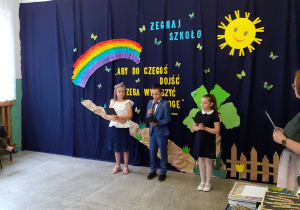 Troje dzieci prezentuje część artystyczną zakończenia