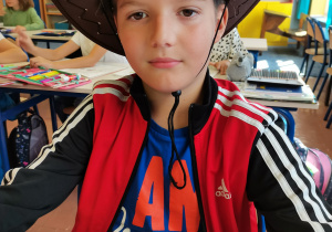 Chłopiec pozuje w kowbojskim kapeluszu.