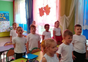 Dzieci z klasy II a w strojach galowych śpiewają hymn narodowy.