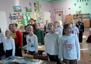 Dzieci z klasy III a w strojach galowych śpiewają hymn narodowy.