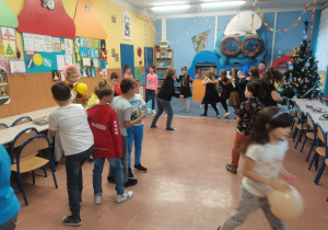 Grupa dzieci tańczy na środku klasy.